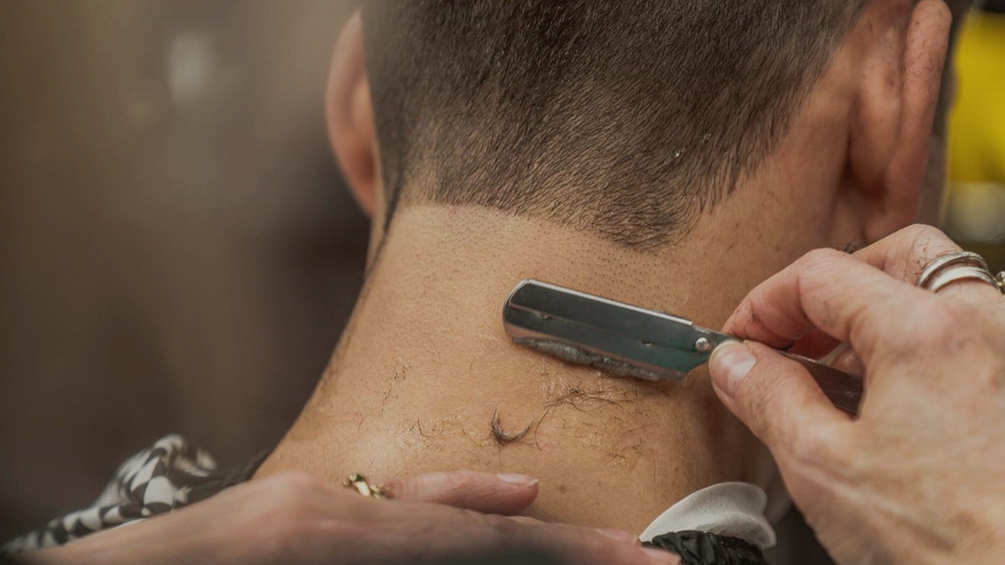 Skilled barber finishing a neck line with a straight razor