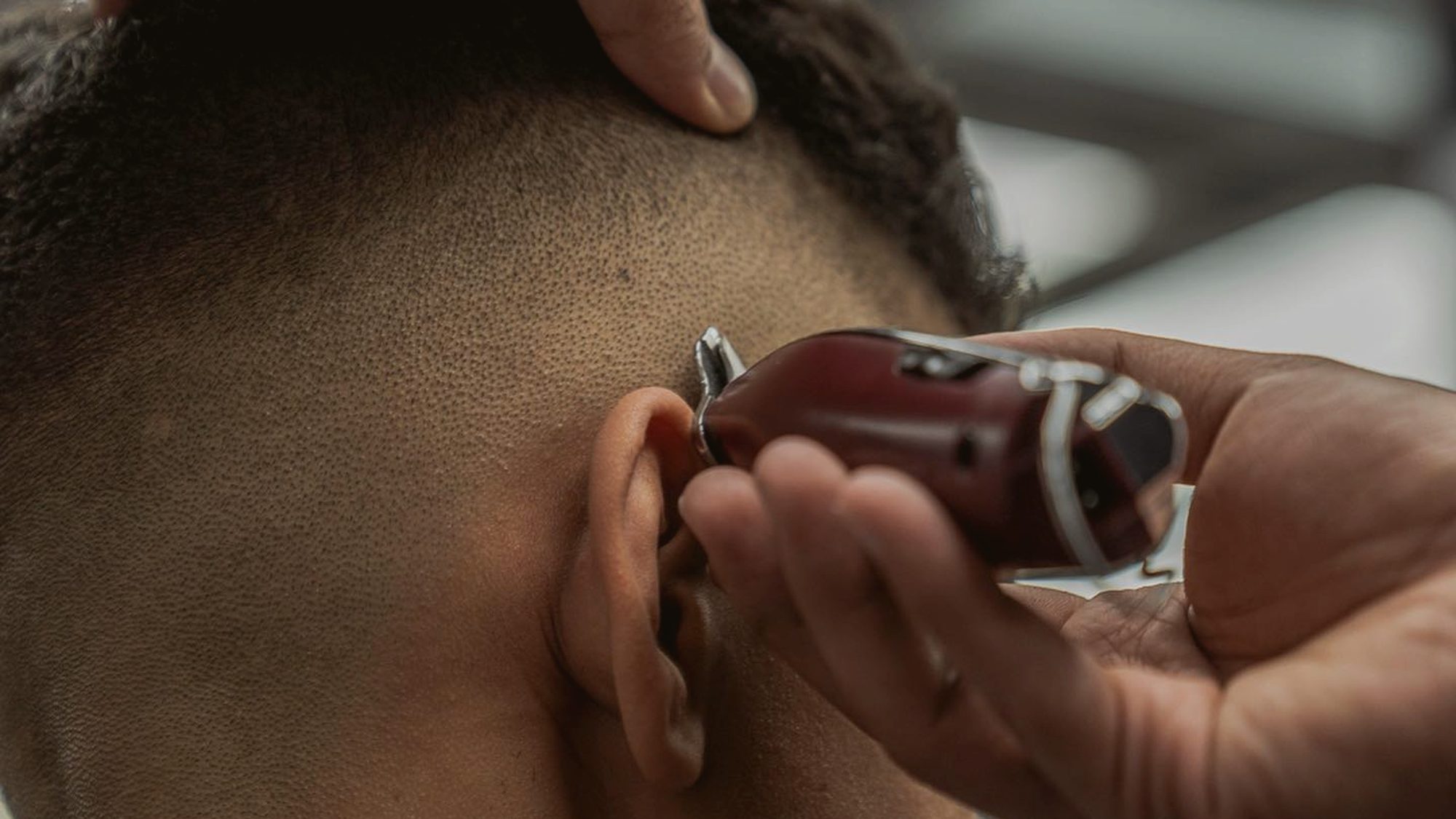Detail shot of clipper precision work behind the ear